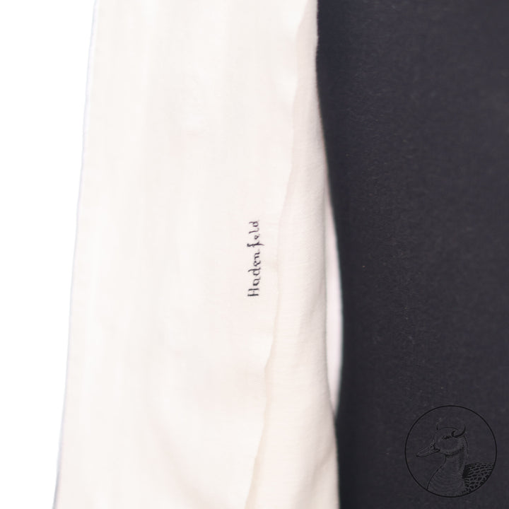 Weißes Jackett (nach neuer Vorschrift) der Kriegsmarine für einen Leutnant der
Küstenartillerie . Das Jackett besitzt aufgesetzte Brust- und Seitentaschen mit Quetschfalten. Die
feuervergoldeten Ankerknöpfe sind sicher mit Sprengringen angebracht, während der
vorschriftsmäßige Metallbrustadler mittels typischer Zwirnschlaufen befestigt ist. Innen finden sich ein Größen- und Herstellerstempel sowie die Namensstickerei
„Hadenfeld“