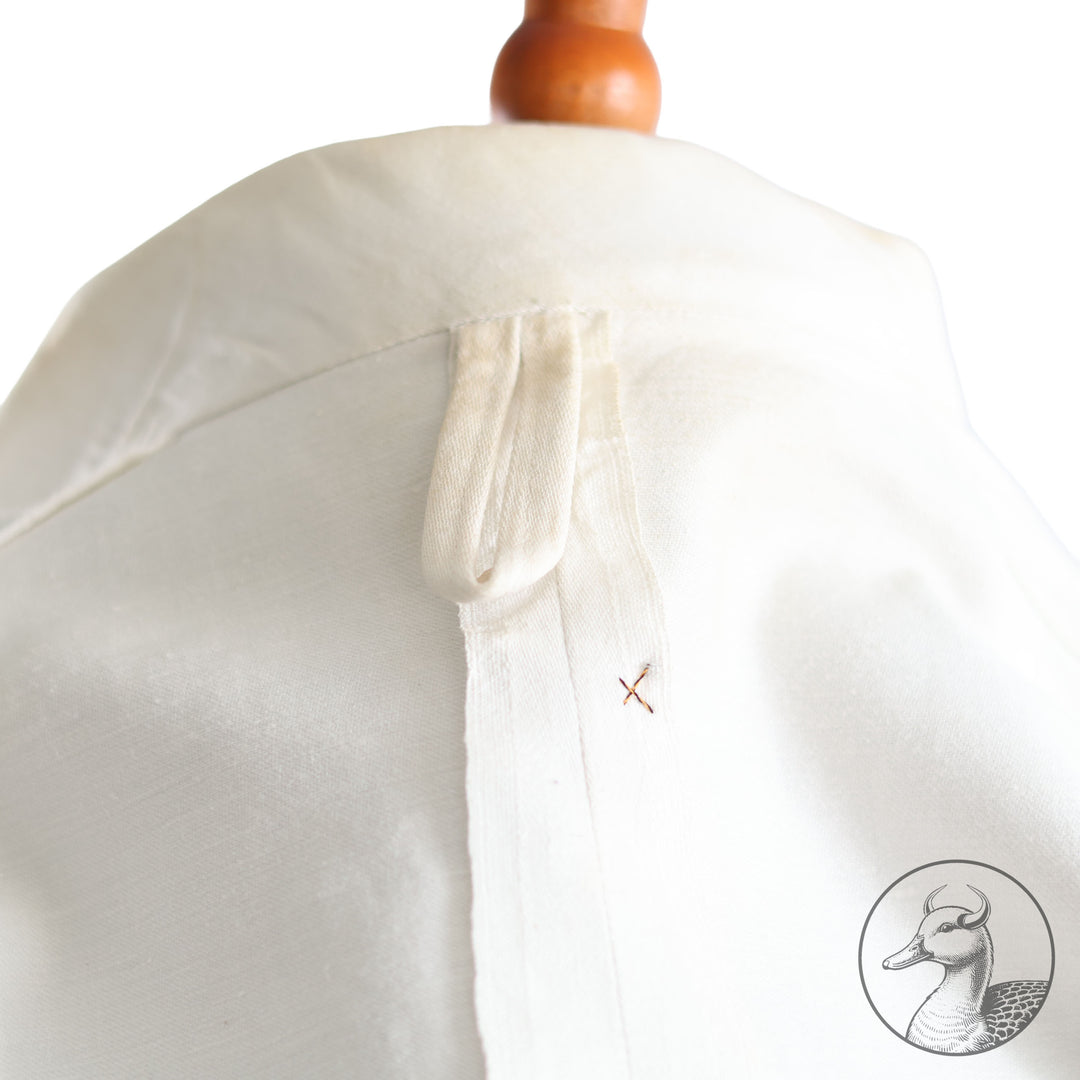 Weißes Jackett (nach neuer Vorschrift) der Kriegsmarine für einen Leutnant der
Küstenartillerie . Das Jackett besitzt aufgesetzte Brust- und Seitentaschen mit Quetschfalten. Die
feuervergoldeten Ankerknöpfe sind sicher mit Sprengringen angebracht, während der
vorschriftsmäßige Metallbrustadler mittels typischer Zwirnschlaufen befestigt ist. Innen finden sich ein Größen- und Herstellerstempel sowie die Namensstickerei
„Hadenfeld“